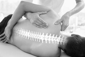 Manual-therapy-copy-min - Human Kinetics Επαγγελματίας μασέρ κάνει μάλαξη στη σπονδυλική στήλη ενός πελάτη σε μασάζ καθαρμός.