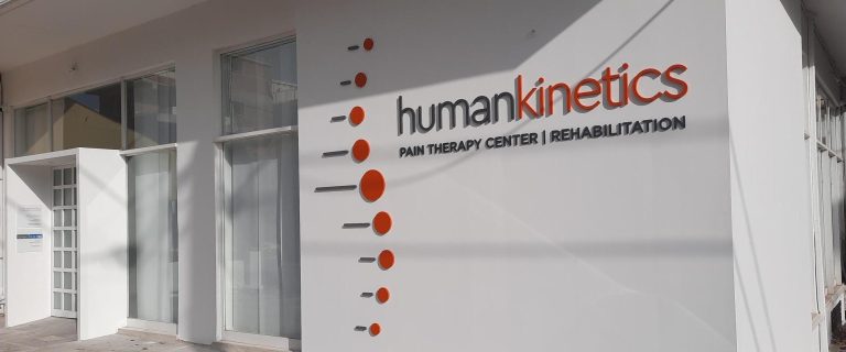 Είσοδος και πρόσοψη του κέντρου φυσικοθεραπείας και βελονισμού Human Kinetics με το λογότυπο στον τοίχο